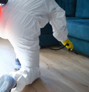 worker protective suit treating with disinfectant solution floor sofa apartment 1